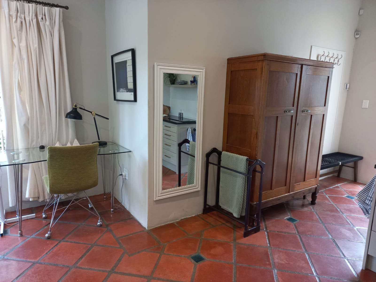 Desk area with glass-top table, wardrobe, and full-length mirror